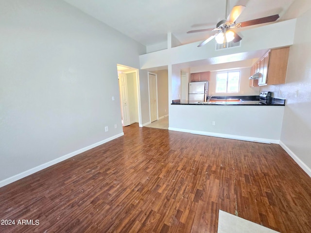 unfurnished living room featuring dark hardwood / wood-style flooring and ceiling fan