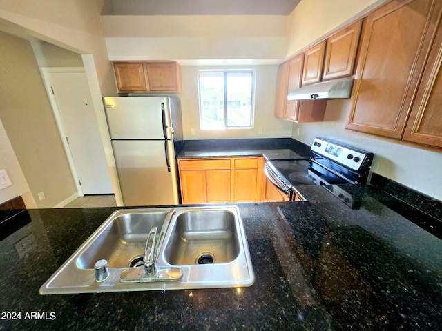 kitchen featuring appliances with stainless steel finishes, sink, and dark stone countertops