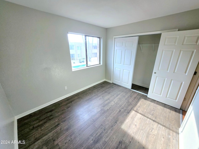 unfurnished bedroom featuring a closet and hardwood / wood-style flooring