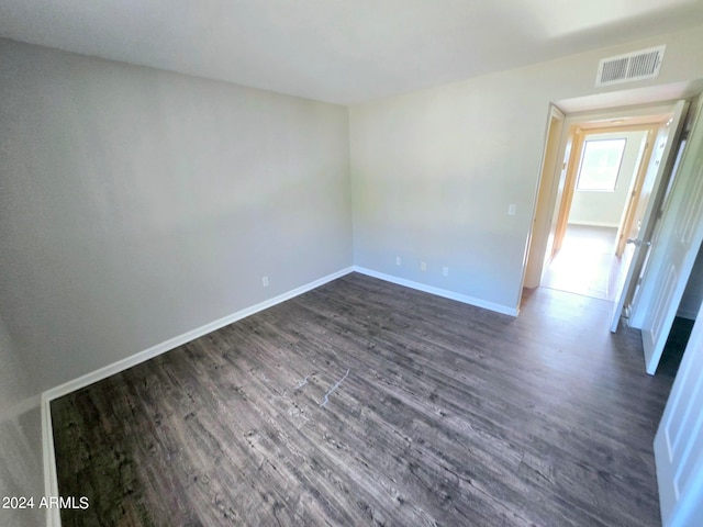 unfurnished room with dark wood-type flooring