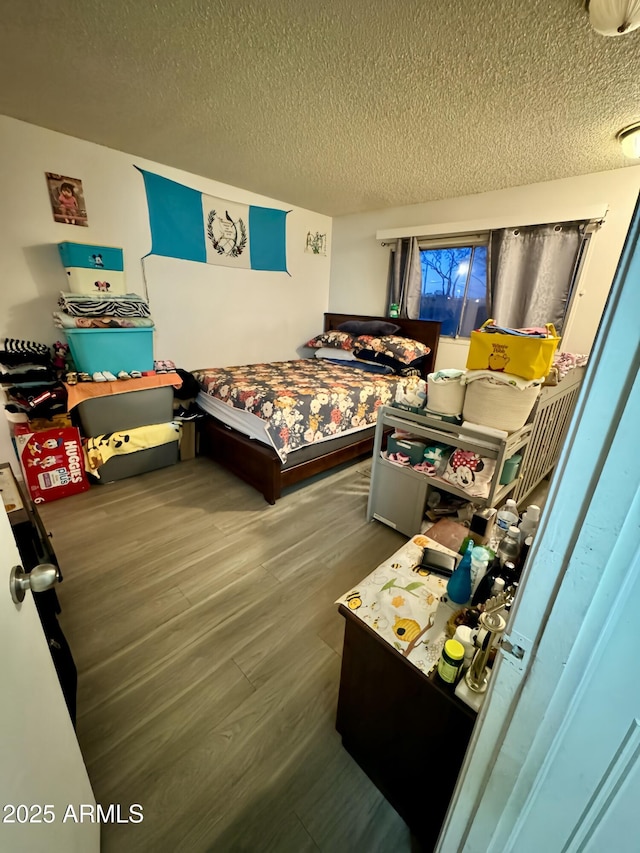 bedroom with hardwood / wood-style floors and a textured ceiling