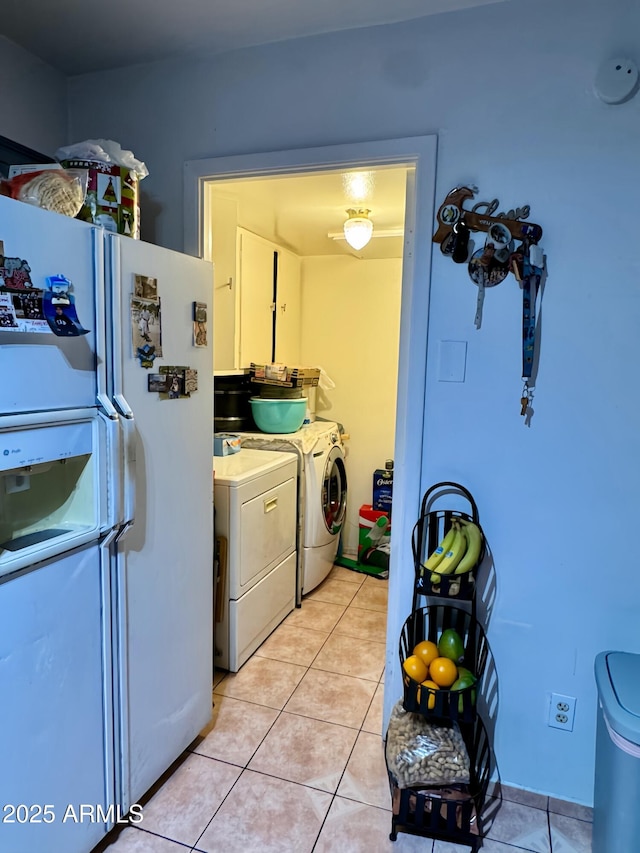 clothes washing area featuring washing machine and clothes dryer and light tile patterned floors