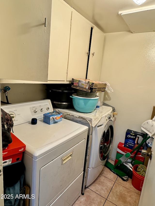 clothes washing area with light tile patterned floors and washer and clothes dryer