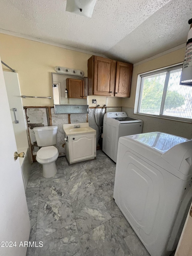 laundry area featuring washing machine and dryer and a textured ceiling