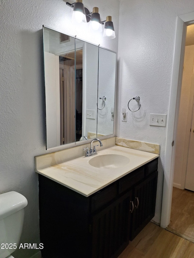 421 S 113th Way, Mesa, AZ 85208 - bathroom with vanity, wood finished floors, toilet, and a textured wall