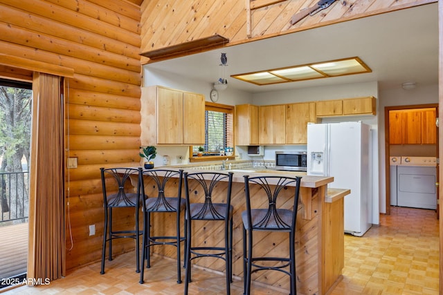 2288 Richenbacher Cir, Overgaard, AZ 85933 - kitchen featuring white refrigerator with ice dispenser, stainless steel microwave, light brown cabinetry, light countertops, and a breakfast bar area
