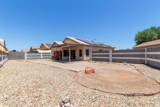 1102 N 5th St, Buckeye, AZ 85326 - rear view of house with solar panels, a fenced backyard, a patio area, and stucco siding