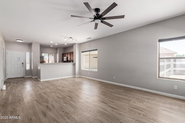 1102 N 5th St, Buckeye, AZ 85326 - unfurnished living room featuring wood finished floors and a ceiling fan