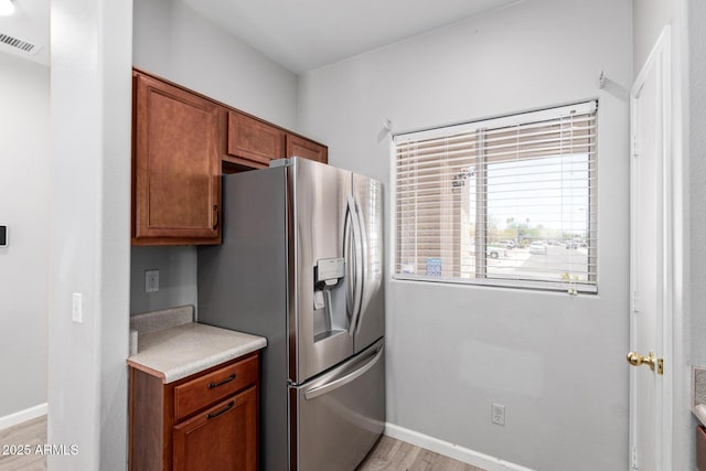 1102 N 5th St, Buckeye, AZ 85326 - kitchen featuring stainless steel refrigerator with ice dispenser, light wood finished floors, light countertops, and brown cabinets