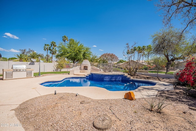 view of swimming pool featuring area for grilling, a fenced backyard, an outdoor fireplace, a patio, and an outdoor kitchen