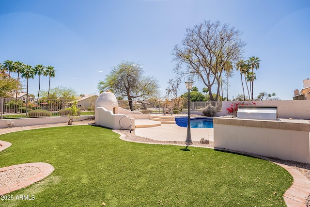 view of yard featuring a fenced in pool, a fenced backyard, and an outdoor kitchen