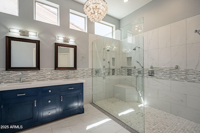 full bathroom with a sink, walk in shower, marble finish floor, and an inviting chandelier