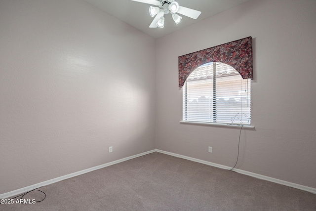 carpeted spare room with baseboards and a ceiling fan