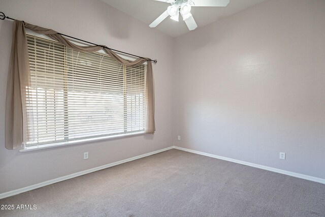 carpeted empty room with ceiling fan and baseboards