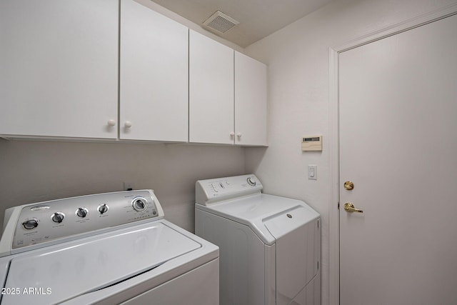 laundry room featuring cabinet space, visible vents, and washer and clothes dryer