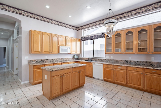 kitchen with white appliances, glass insert cabinets, and light stone counters