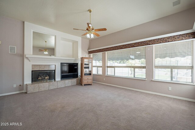 unfurnished living room featuring a tiled fireplace, baseboards, a ceiling fan, and carpet