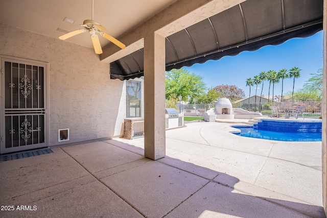 view of patio with fence, exterior kitchen, ceiling fan, and a fenced in pool