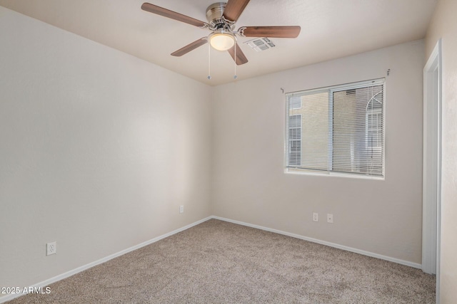 carpeted spare room with visible vents, baseboards, and ceiling fan