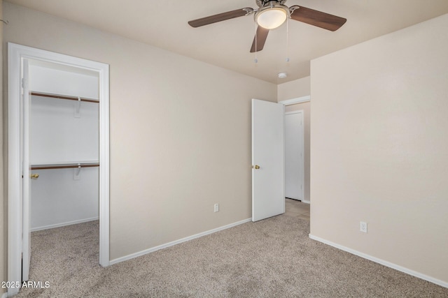 unfurnished bedroom with a ceiling fan, a closet, carpet flooring, baseboards, and a spacious closet