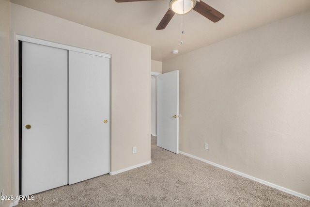 unfurnished bedroom with a closet, carpet floors, baseboards, and ceiling fan