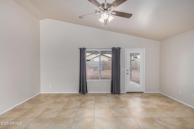 empty room with vaulted ceiling, light tile patterned floors, a ceiling fan, and baseboards