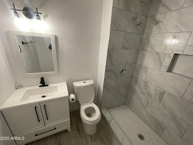 bathroom featuring a tile shower and toilet