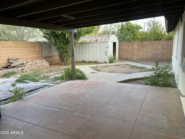 view of patio with a fenced backyard, an outbuilding, and a storage unit