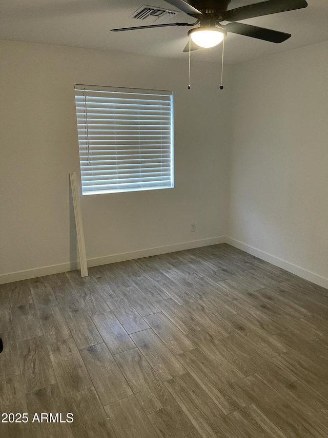unfurnished room with baseboards, visible vents, wood finished floors, and ceiling fan