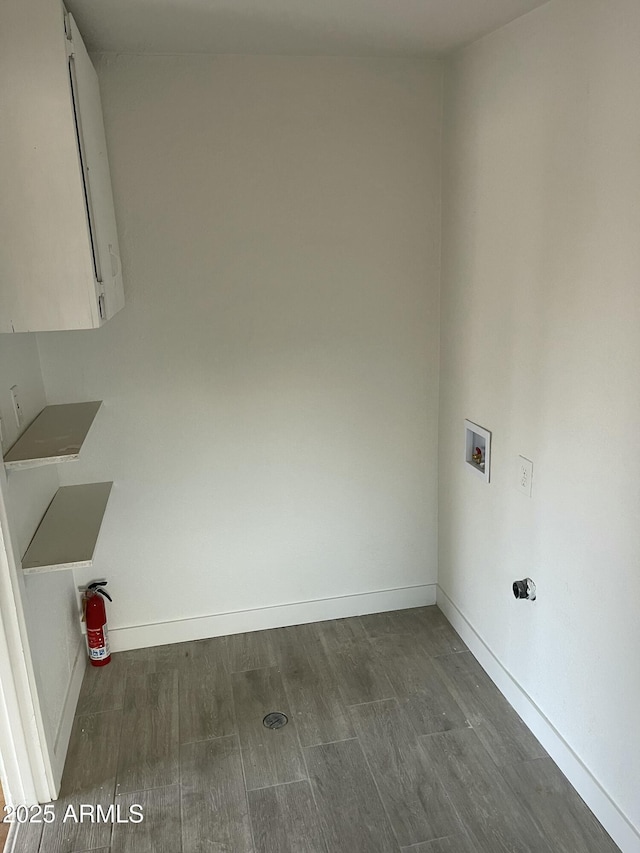 clothes washing area featuring washer hookup, cabinet space, baseboards, and dark wood-style flooring