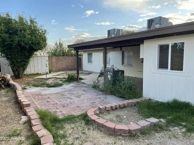 rear view of house featuring a patio, fence, and central AC unit