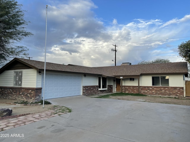 ranch-style house with brick siding, driveway, a shingled roof, and an attached garage