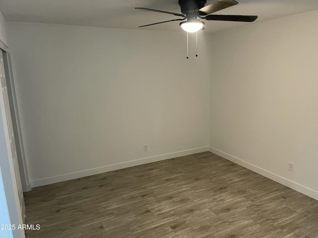 unfurnished room with a ceiling fan, baseboards, and wood finished floors