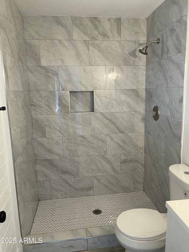 bathroom with toilet and a tile shower