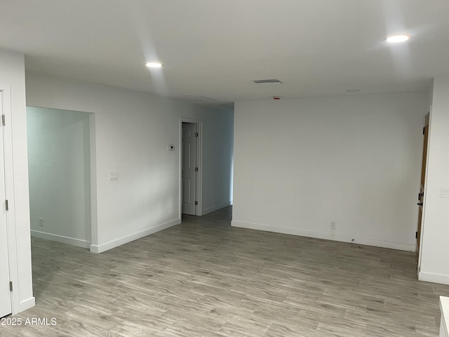 unfurnished room with baseboards, recessed lighting, visible vents, and light wood-style floors