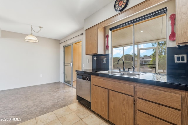 kitchen featuring pendant lighting, dishwasher, backsplash, sink, and light tile patterned floors