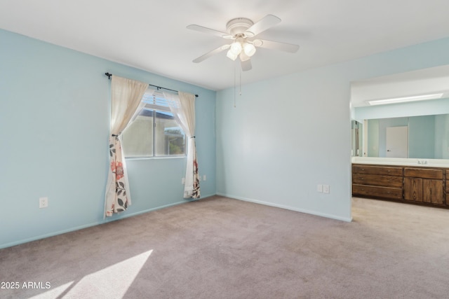 unfurnished bedroom featuring ensuite bath, ceiling fan, sink, and light carpet