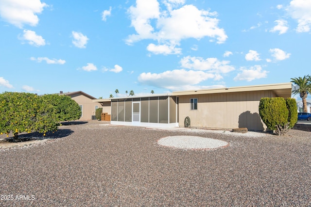 rear view of property featuring a sunroom