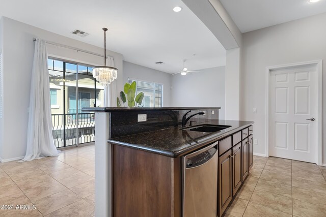 kitchen featuring dark stone counters, ceiling fan with notable chandelier, dishwasher, and a wealth of natural light