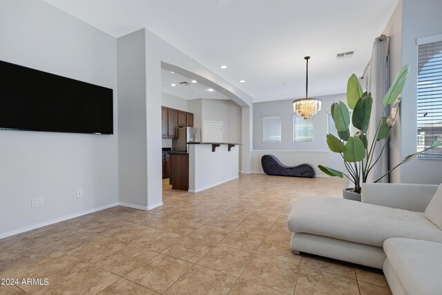 living room with light tile patterned floors and a notable chandelier