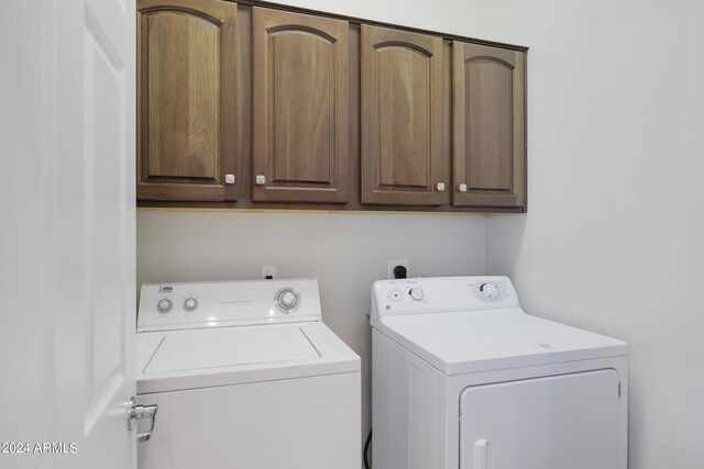 washroom with cabinets and washing machine and dryer