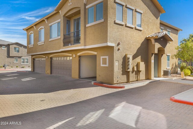 view of front of home with a garage and central AC unit