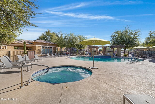 view of swimming pool featuring a community hot tub and a patio area