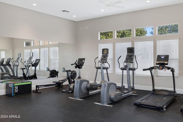 gym with a high ceiling and ceiling fan