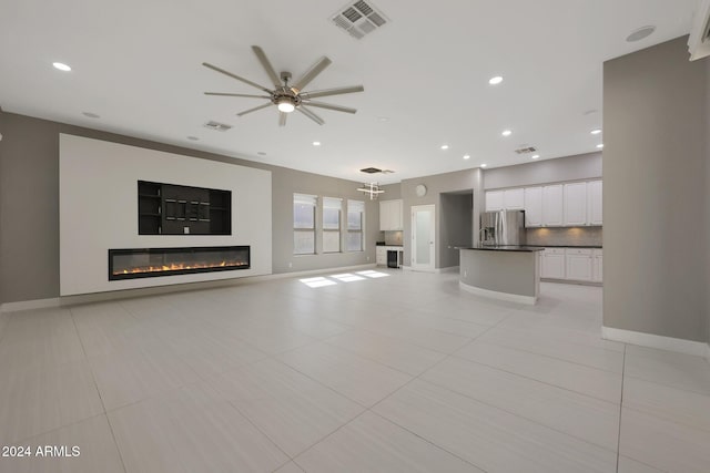 unfurnished living room with ceiling fan and light tile patterned flooring