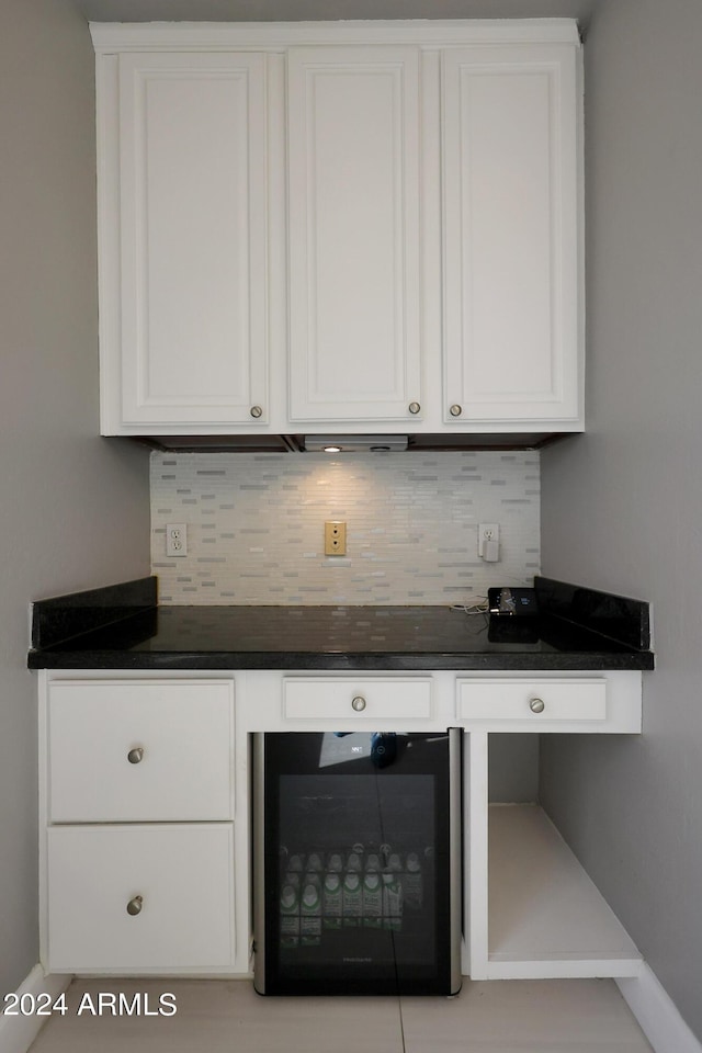 bar featuring white cabinetry, backsplash, and beverage cooler