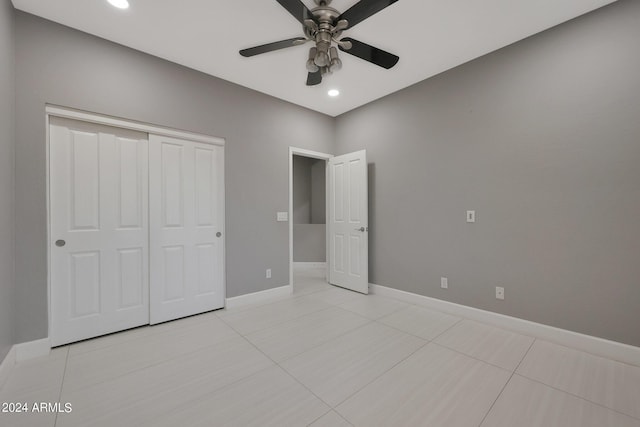 unfurnished bedroom featuring light tile patterned flooring, ceiling fan, and a closet