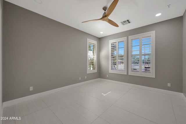 tiled spare room with ceiling fan