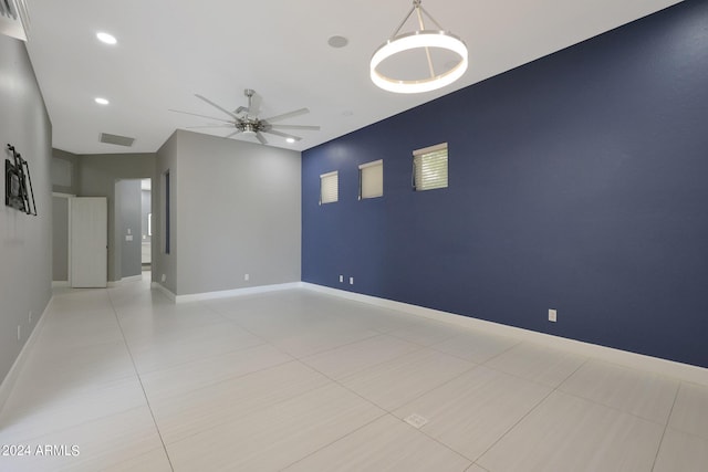 tiled spare room with ceiling fan