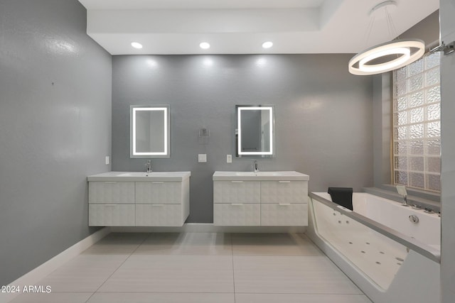 bathroom with a tub to relax in, vanity, and tile patterned floors